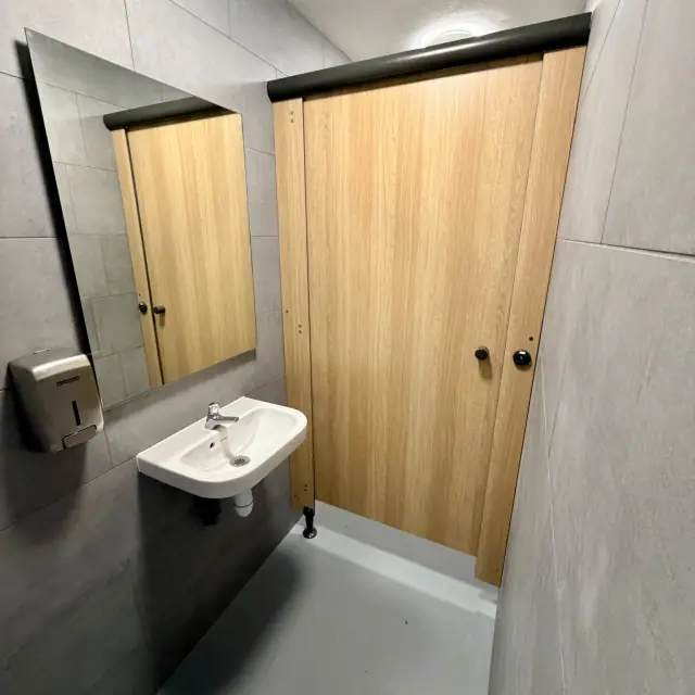 Sanitaires: cloisons bois, carrelage gris — Agence Firma